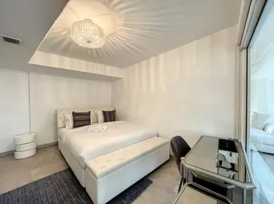 a white bedroom with a bed and a table at Rimal 3 - Incredible Two Bedroom in Dubai