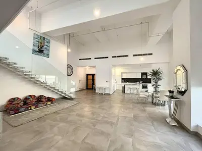 a living room with a staircase and a dining room at Rimal 3 - Incredible Two Bedroom in Dubai