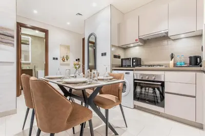a dining room with a table and chairs in a kitchen at STAY BY LATINEM Luxury 1BR Holiday Home CVR A1504 near Burj Khalifa in Dubai