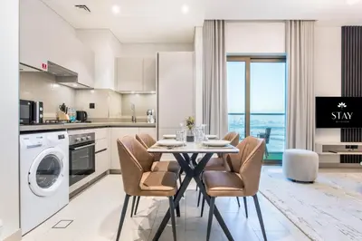 a kitchen with a table and chairs in a kitchen at STAY BY LATINEM Luxury 1BR Holiday Home CVR A1504 near Burj Khalifa in Dubai
