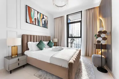 a bedroom with a large bed and a large window at Stayis -1 BR Burj Khalifa View Partial in Dubai