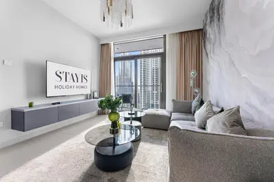 a living room with a couch and a tv at Stayis -1 BR Burj Khalifa View Partial in Dubai