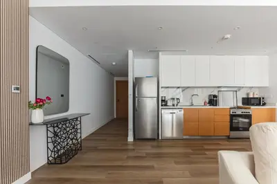 a kitchen with stainless steel appliances and wooden cabinets at La Vie, JBR private beach, private parking and pool in Dubai