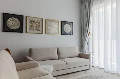 a living room with a couch and some pictures on the wall at La Vie, JBR private beach, private parking and pool in Dubai
