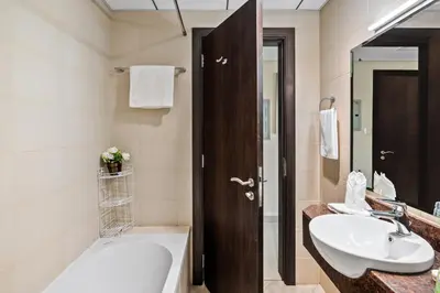 a bathroom with a tub and a sink and a bath tub at Modern Studio Sports City Pool & City Views in Dubai