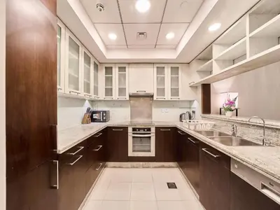 a large kitchen with brown cabinets and a sink at Golden Homes Boulverd Central 1BHK BLUE HEAVEN Near Dubai mall & burj khalifa Downtown Dubai in Dubai