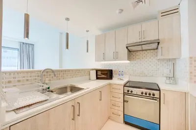 a kitchen with a sink and a stove top oven at Seven Palm 1 Bed with Rooftop Infinity Pool in Dubai