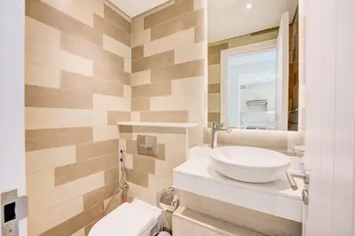 a bathroom with a sink and a toilet at Seven Palm 1 Bed with Rooftop Infinity Pool in Dubai
