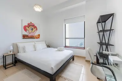 a white bedroom with a bed and a window at JBR High Floor 2 Bed with full Al Ain View in Dubai
