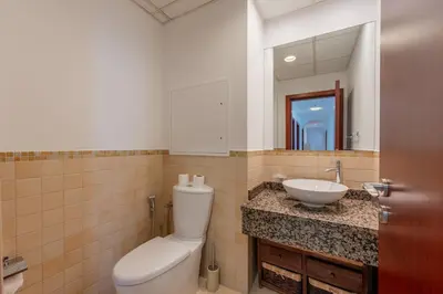 a bathroom with a toilet and a sink and a mirror at JBR High Floor 2 Bed with full Al Ain View in Dubai