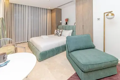 a hotel room with a bed and a chair at Designer Glam Studio Steps from Burj Khalifa in Dubai