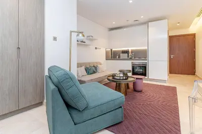 a living room with a couch and a chair and a table at Designer Glam Studio Steps from Burj Khalifa in Dubai