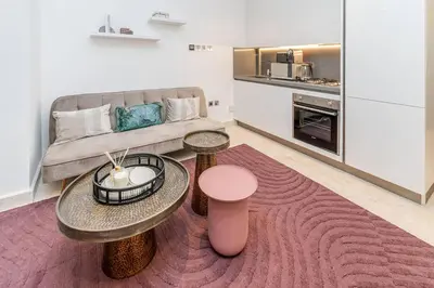 a living room with two tables and a couch at Designer Glam Studio Steps from Burj Khalifa in Dubai