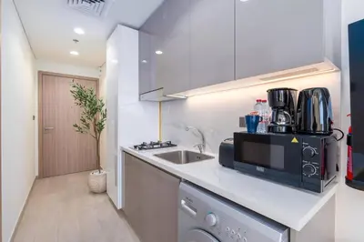 a kitchen with a sink and a microwave at Studio 12min from Burj Khalifa - Azizi Riviera 32 - Dubai in Dubai