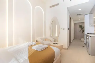 a white room with a bed and a bathroom at Studio 12min from Burj Khalifa - Azizi Riviera 32 - Dubai in Dubai