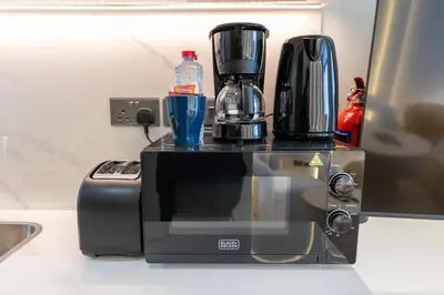 a microwave sitting on top of a kitchen counter at Studio 12min from Burj Khalifa - Azizi Riviera 32 - Dubai in Dubai