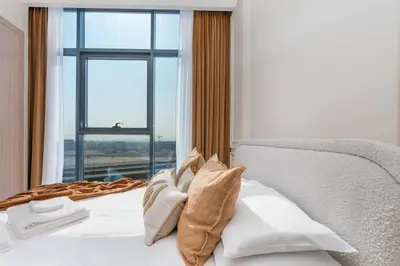 a bedroom with a white bed with a window at 2bdr 12min from Downtown in Dubai