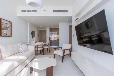 a living room with a white couch and a table at 2bdr 12min from Downtown in Dubai