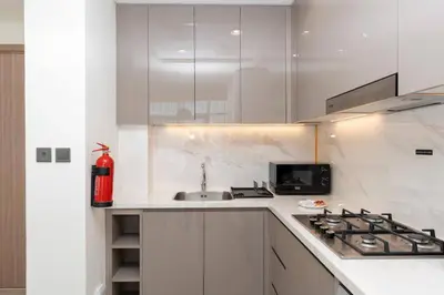 a white kitchen with a stove and a sink at 2bdr 12min from Downtown in Dubai