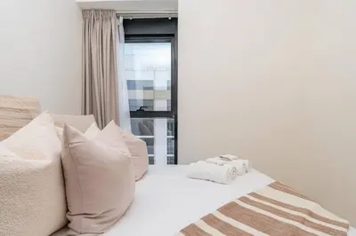 a white bed with white pillows and a window at 2bdr 12min from Downtown in Dubai