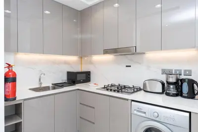 a kitchen with white cabinets and a stove top oven at 2bdr 12min from Downtown in Dubai