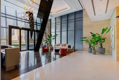 a lobby with potted plants in a building at Luxury Glam Studio Near Burj Khalifa Downtown in Dubai