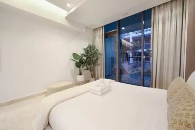 a white bed in a room with a window at Luxury Glam Studio Near Burj Khalifa Downtown in Dubai