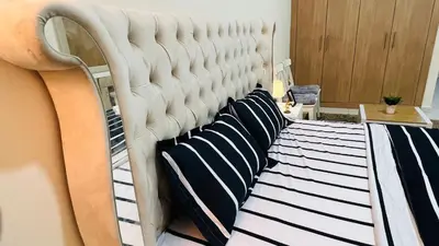 a bed with black and white pillows on it at Master Room with attach Bathroom Near Mall of the Emirates in Dubai
