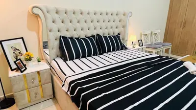 a bedroom with a large bed with a black and white blanket at Master Room with attach Bathroom Near Mall of the Emirates in Dubai