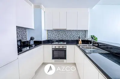 a white kitchen with a sink and a stove at 1BR Apartment in Paramount Midtown in Dubai