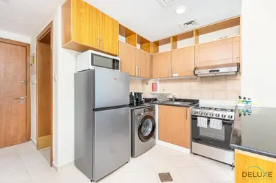 a kitchen with a stainless steel refrigerator and a dishwasher at Comfortable Studio at Lago Vista A Dubai Production City by Deluxe Holiday Homes in Dubai