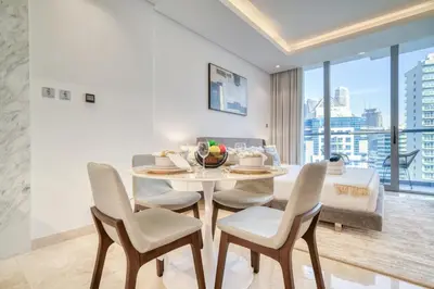 a dining room with a table and chairs with a view at Canal-View Serenity: Modern Studio in Sterling in Dubai