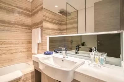 a bathroom with a white sink and a bath tub at Canal-View Serenity: Modern Studio in Sterling in Dubai