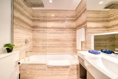 a bathroom with a tub and a sink at Canal-View Serenity: Modern Studio in Sterling in Dubai