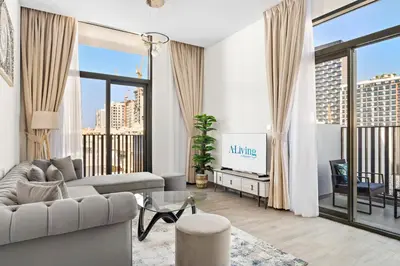 a living room with a couch and a tv at ALiving Stylish 1BR Apartment I Fully Furnished with Balcony I Belgravia Square, JVC in Dubai