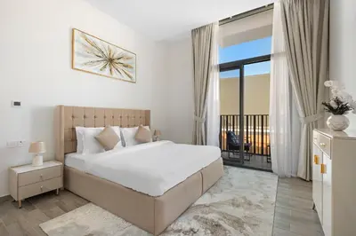 a white bedroom with a bed and a balcony at ALiving Stylish 1BR Apartment I Fully Furnished with Balcony I Belgravia Square, JVC in Dubai