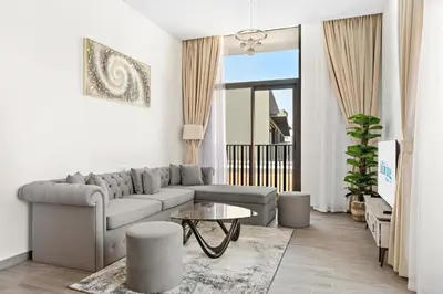 a living room with a couch and a table at ALiving Stylish 1BR Apartment I Fully Furnished with Balcony I Belgravia Square, JVC in Dubai