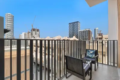 a balcony with a chair and a view of the city at ALiving Stylish 1BR Apartment I Fully Furnished with Balcony I Belgravia Square, JVC in Dubai