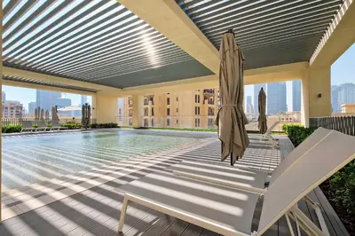 a swimming pool with a umbrella and a chair and a swimming pool at Silkhaus Luxurious 1 BDR Stunning View in Dubai