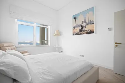a white bedroom with a bed and a window at Seaview-Shoreline4-Palm Jumeirah in Dubai