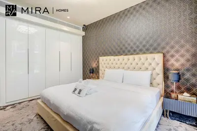 a bedroom with a large bed and a wall at Mira Holiday Homes - Luxury 1 bedroom in Bluewaters Island in Dubai