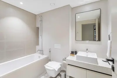 a bathroom with a sink and a toilet and a mirror at Silkhaus Beach Lovers 1BDR with Marina View in Dubai
