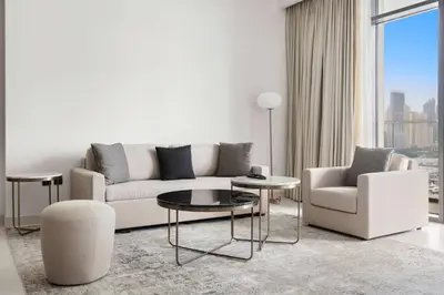 a living room with a couch and a table and chairs at Silkhaus Beach Lovers 1BDR with Marina View in Dubai