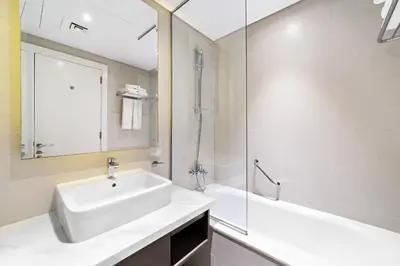a white bathroom with a sink and a shower at ALiving Deluxe Studio I DAMAC Maison Prive, Business Bay -1204 in Dubai