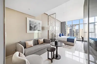 a living room with a couch and a bed at ALiving Deluxe Studio I DAMAC Maison Prive, Business Bay -1204 in Dubai