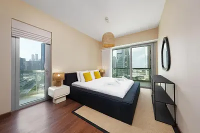 a bedroom with a bed and a large window at Discover unmatched Comfort in Downtown Dubai in Dubai
