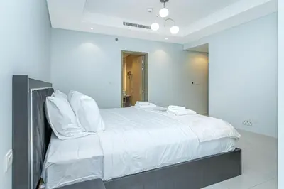 a bedroom with a large white bed with white pillows at Stylish 2BR Retreat Wi-Fi & Pool Access in Dubai