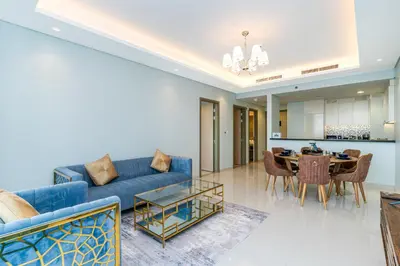 a living room with a blue couch and a table at Stylish 2BR Retreat Wi-Fi & Pool Access in Dubai