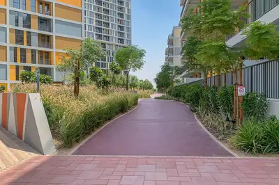 a walking path in a city with tall buildings at Frank Porter - Noor 3 Midtown in Dubai