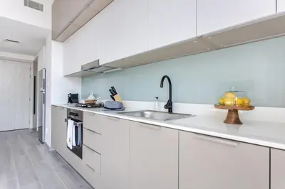 a kitchen with white cabinets and a sink at Frank Porter - Noor 3 Midtown in Dubai
